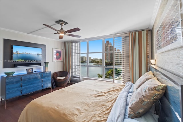 bedroom with a water view, crown molding, ceiling fan, dark hardwood / wood-style flooring, and a wall of windows