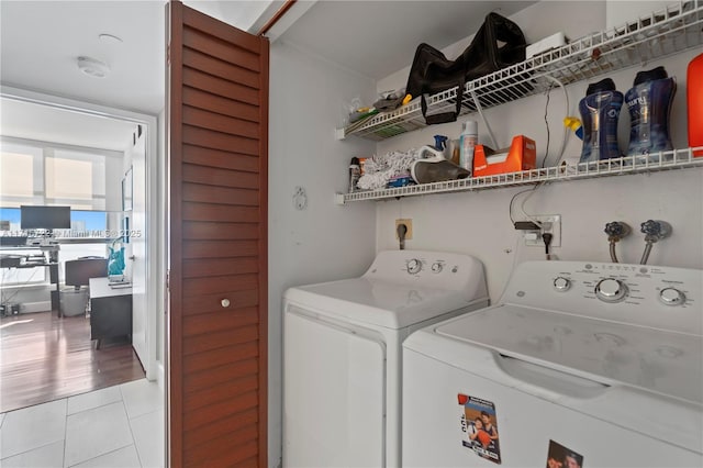 laundry area featuring washing machine and dryer and light tile patterned floors