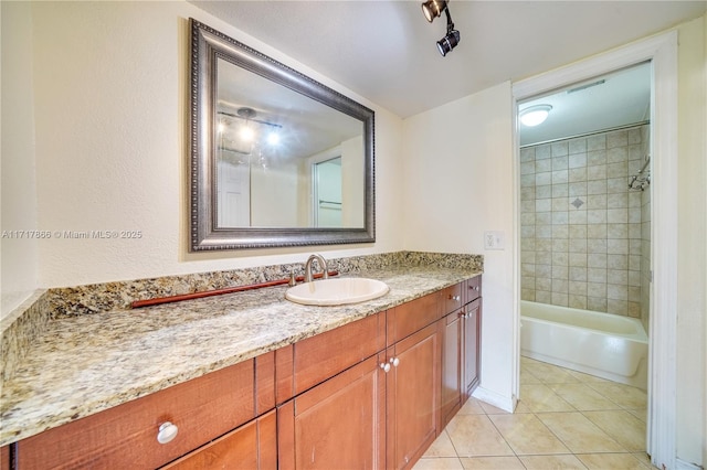 bathroom featuring tile patterned flooring, tiled shower / bath combo, and vanity