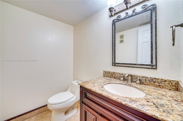 bathroom with tile patterned flooring, vanity, and toilet