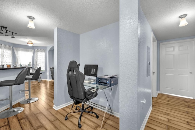 office space featuring a textured ceiling and light hardwood / wood-style flooring