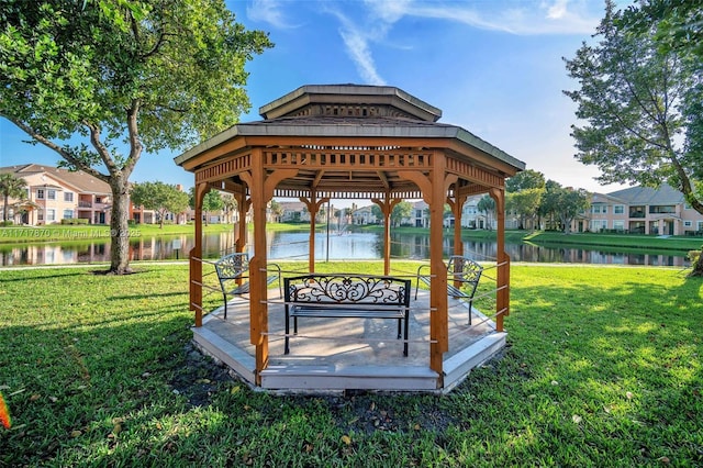 view of property's community featuring a gazebo, a water view, and a lawn