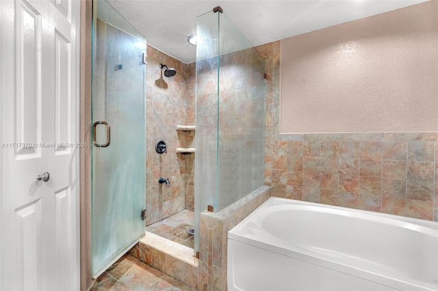 bathroom with shower with separate bathtub and a textured ceiling