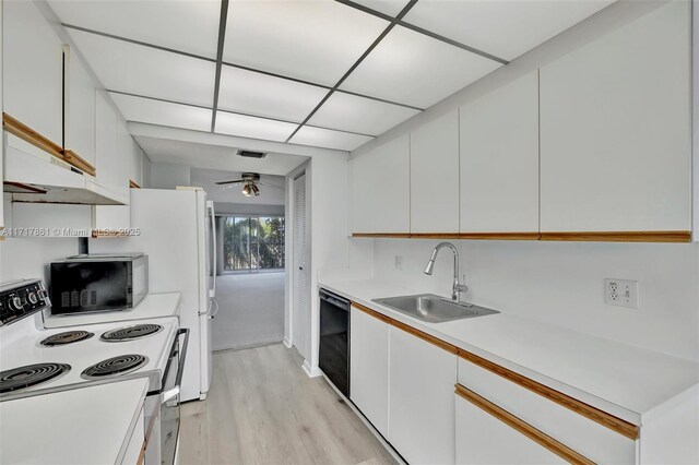 kitchen with white range with electric stovetop, black dishwasher, white cabinets, and sink