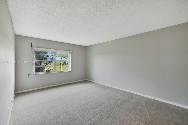 carpeted empty room with a textured ceiling