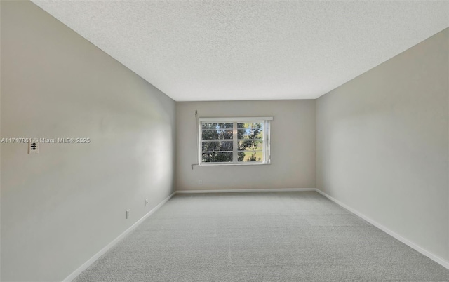 spare room with a textured ceiling and light carpet