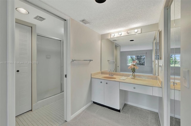 bathroom with an enclosed shower, vanity, and a textured ceiling