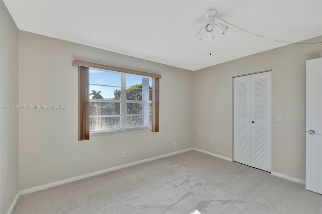 unfurnished bedroom featuring light carpet and a closet