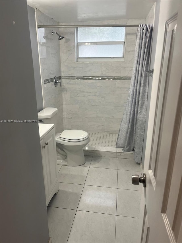 bathroom with tile patterned flooring, vanity, toilet, and curtained shower