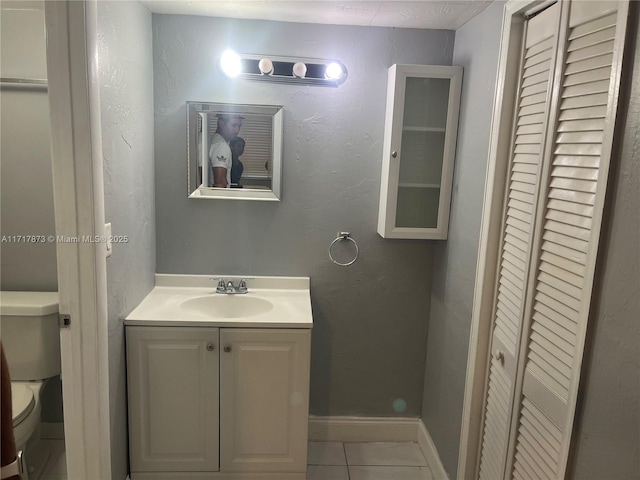 bathroom with tile patterned floors, vanity, and toilet