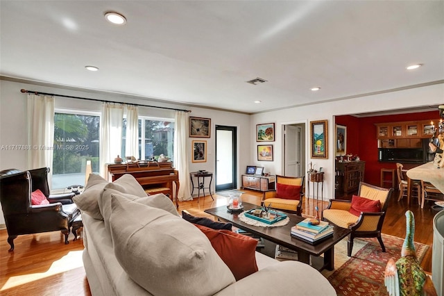 living room with light hardwood / wood-style flooring and crown molding