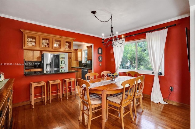 dining space featuring crown molding, dark hardwood / wood-style flooring, and a notable chandelier