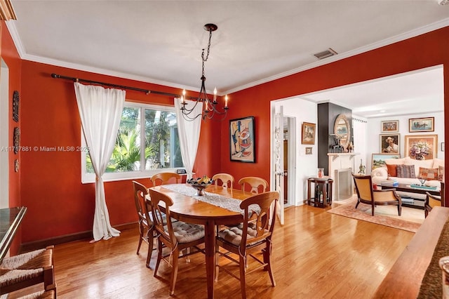 dining room featuring hardwood / wood-style floors, a chandelier, and crown molding