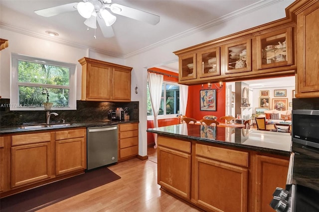 kitchen with dark stone counters, stainless steel dishwasher, crown molding, backsplash, and sink