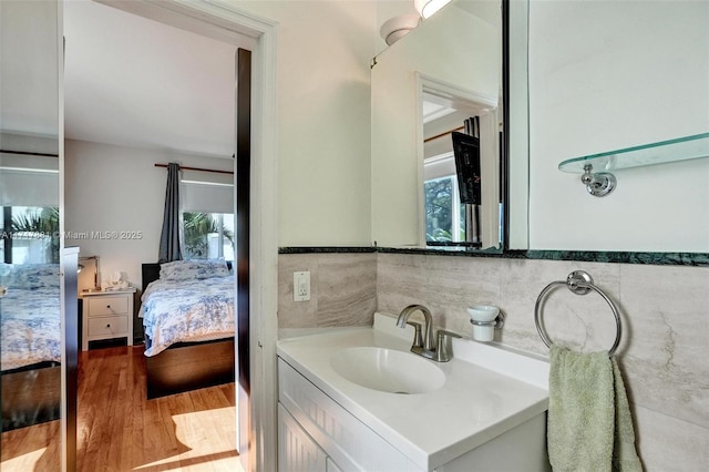 bathroom featuring hardwood / wood-style flooring, tile walls, and vanity