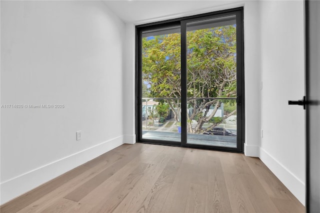 empty room featuring light hardwood / wood-style floors and floor to ceiling windows