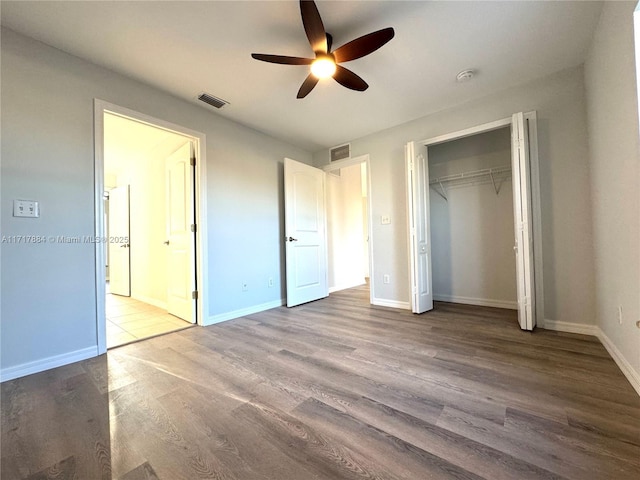 unfurnished bedroom with hardwood / wood-style floors, ceiling fan, and a closet