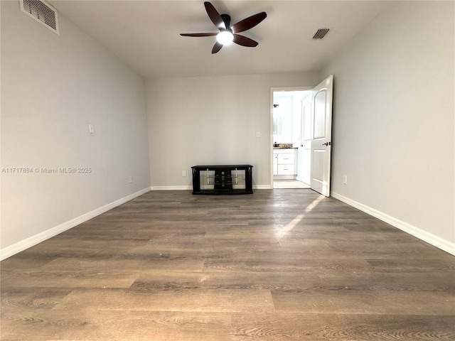 unfurnished living room featuring ceiling fan and dark hardwood / wood-style flooring