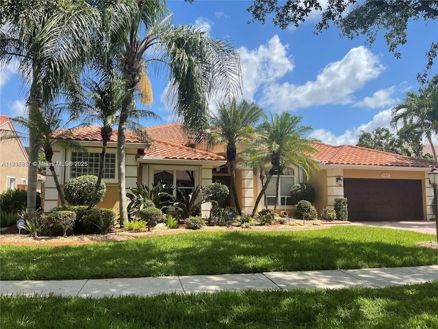 mediterranean / spanish home with a front lawn and a garage