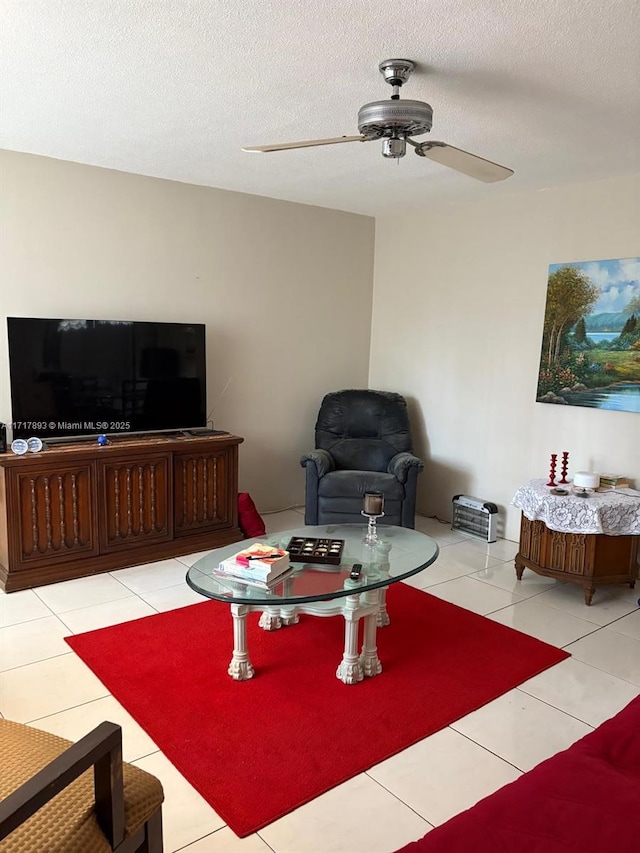 tiled living room featuring ceiling fan and a textured ceiling