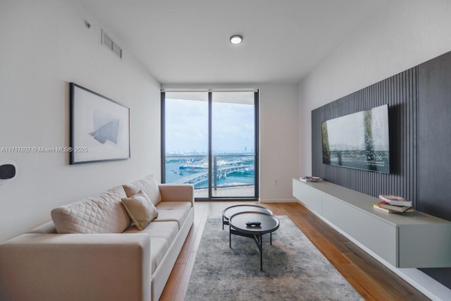 living room with floor to ceiling windows and dark wood-type flooring