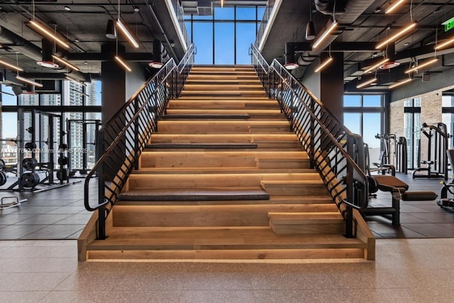 stairway featuring a towering ceiling