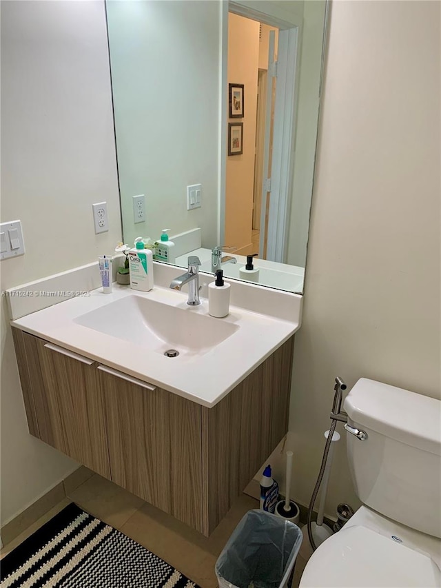 bathroom featuring tile patterned flooring, vanity, and toilet