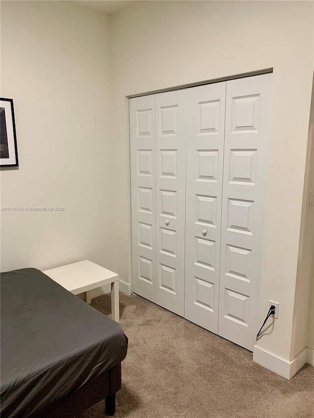 bedroom featuring a closet and light colored carpet