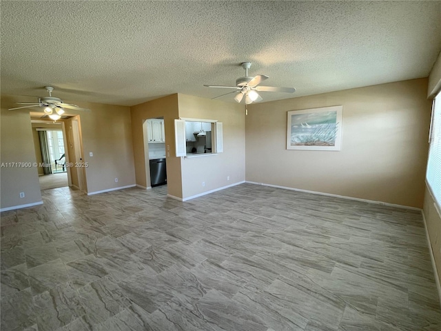 unfurnished living room featuring ceiling fan and a textured ceiling