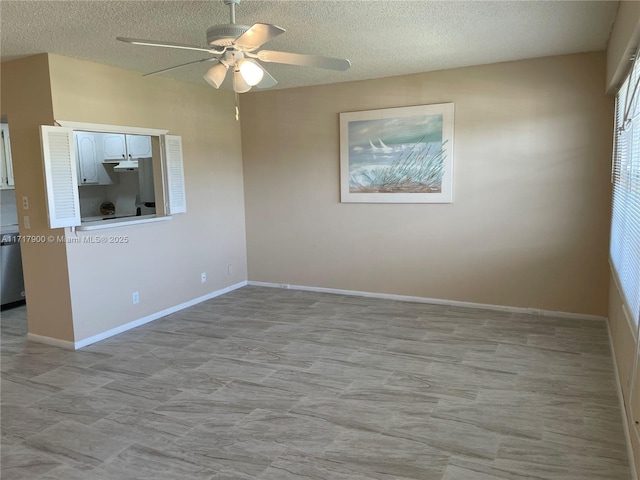 unfurnished room with ceiling fan and a textured ceiling