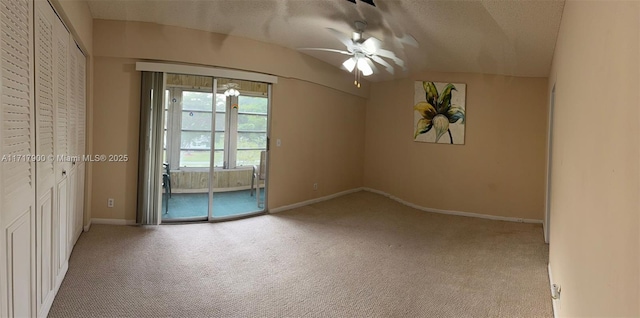 spare room featuring ceiling fan, light colored carpet, and a textured ceiling