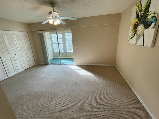 unfurnished bedroom with carpet flooring, ceiling fan, a textured ceiling, and a closet