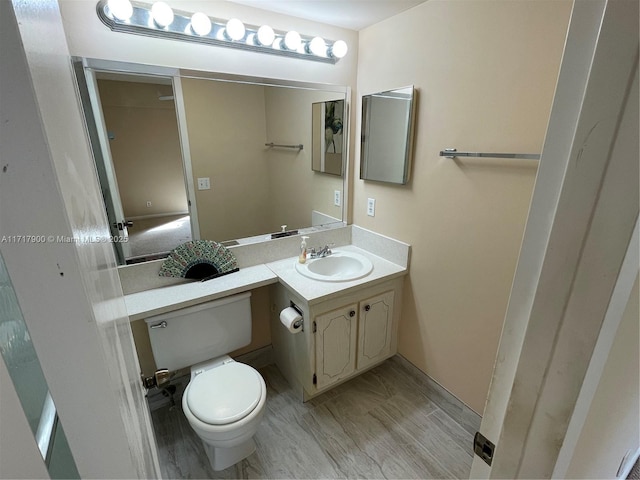 bathroom featuring hardwood / wood-style floors, vanity, and toilet