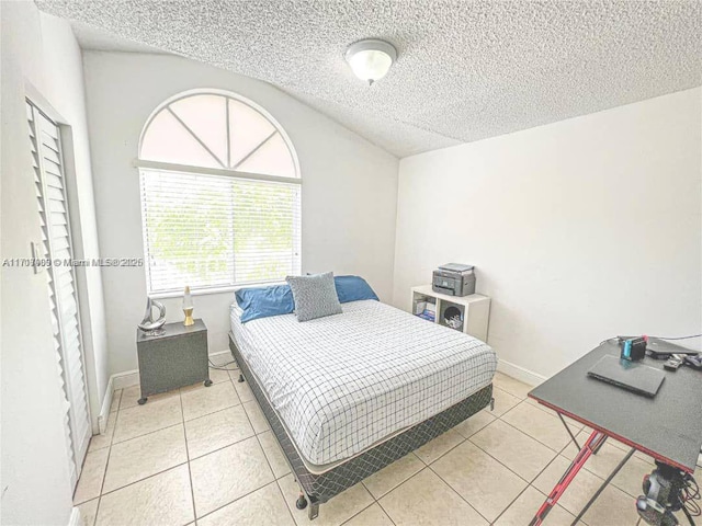 bedroom with light tile patterned flooring and a textured ceiling