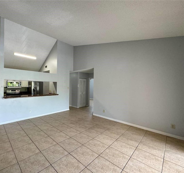 unfurnished living room featuring light tile patterned flooring, a textured ceiling, and high vaulted ceiling