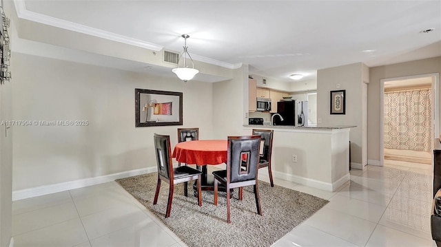 dining room featuring light tile patterned floors, ornamental molding, and sink