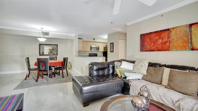 living room featuring sink, light tile patterned floors, and crown molding