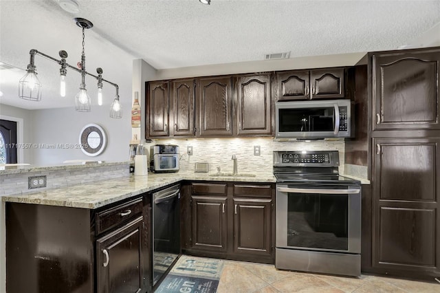 kitchen featuring appliances with stainless steel finishes, dark brown cabinetry, light stone counters, and sink