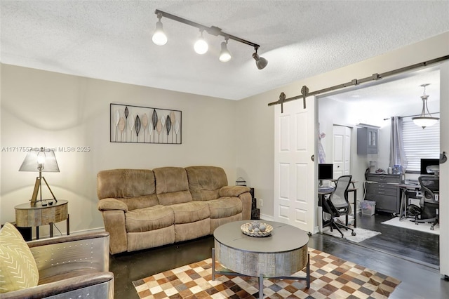 living room with a barn door and a textured ceiling