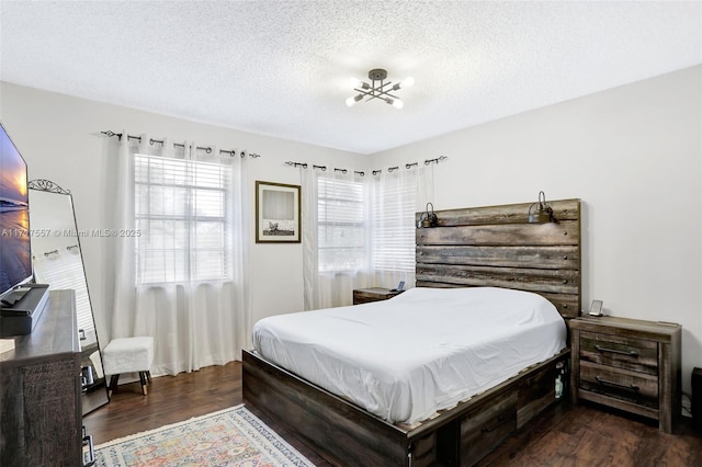 bedroom with dark hardwood / wood-style flooring and a textured ceiling