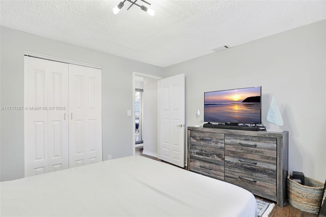 bedroom with a textured ceiling and a closet