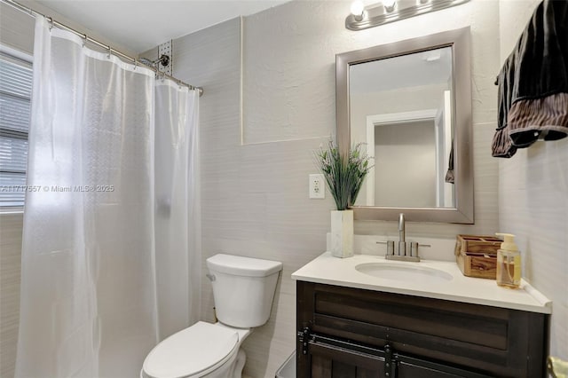 bathroom with a shower with shower curtain, vanity, and toilet