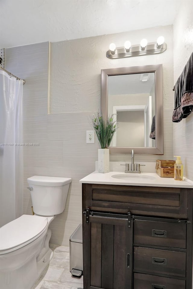 bathroom with vanity, toilet, and walk in shower