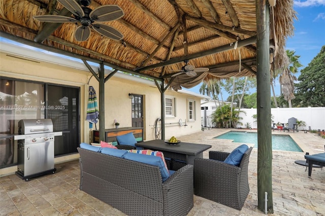 view of patio with a fenced in pool, area for grilling, and ceiling fan