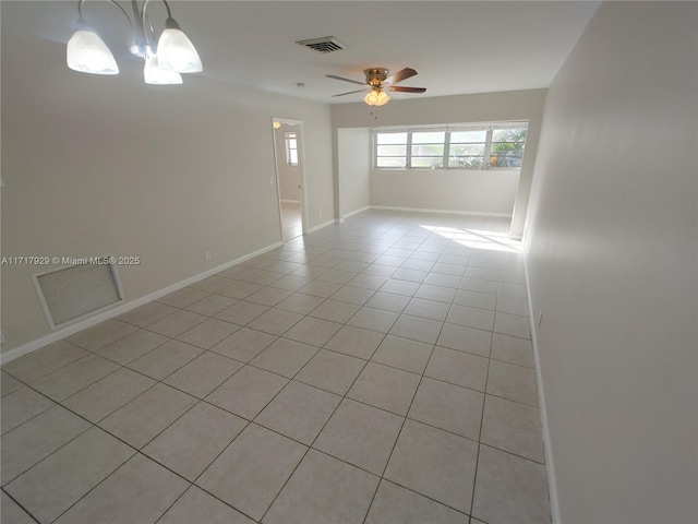 unfurnished room with ceiling fan with notable chandelier and light tile patterned floors