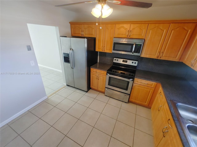 kitchen with appliances with stainless steel finishes, backsplash, ceiling fan, sink, and light tile patterned floors