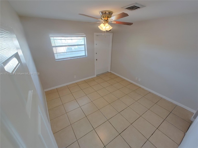 tiled empty room featuring ceiling fan