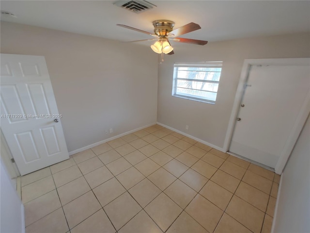 tiled spare room featuring ceiling fan