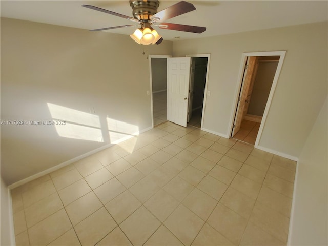 tiled spare room featuring ceiling fan