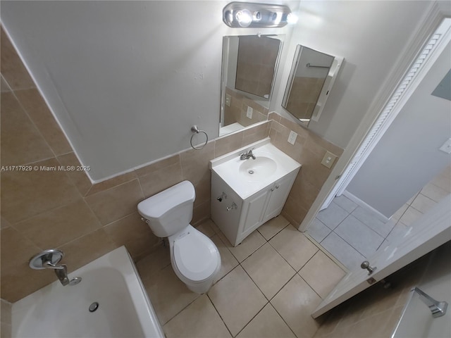 bathroom with tile patterned floors, vanity, toilet, and tile walls